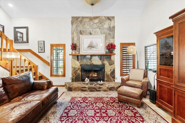 living room featuring light tile patterned flooring, a fireplace, and a high ceiling