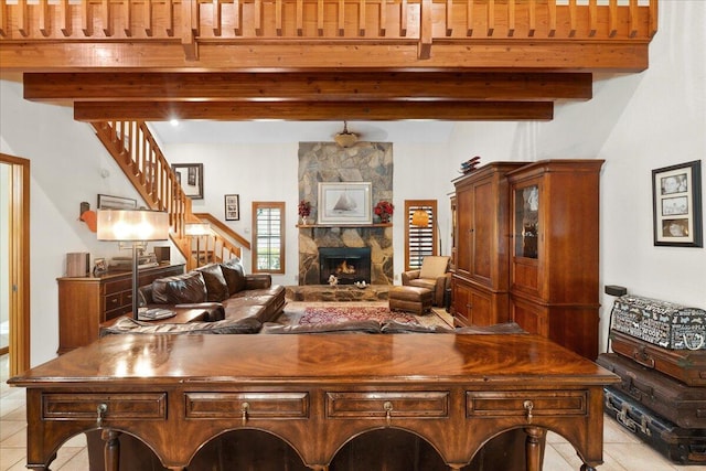 tiled living room with beamed ceiling and a stone fireplace