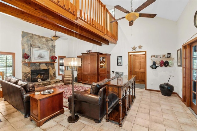 living room featuring a towering ceiling, a stone fireplace, and light tile patterned flooring