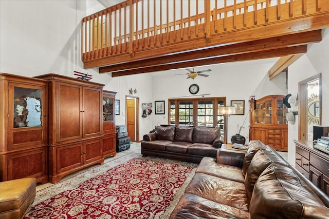 living room with beam ceiling, ceiling fan, and a high ceiling