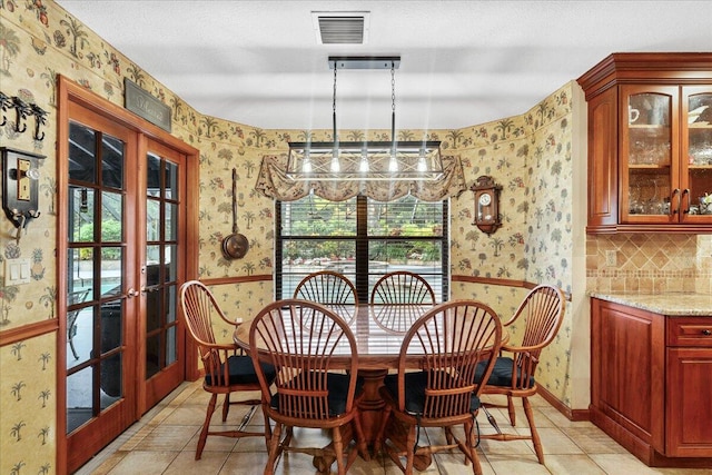 tiled dining area featuring french doors