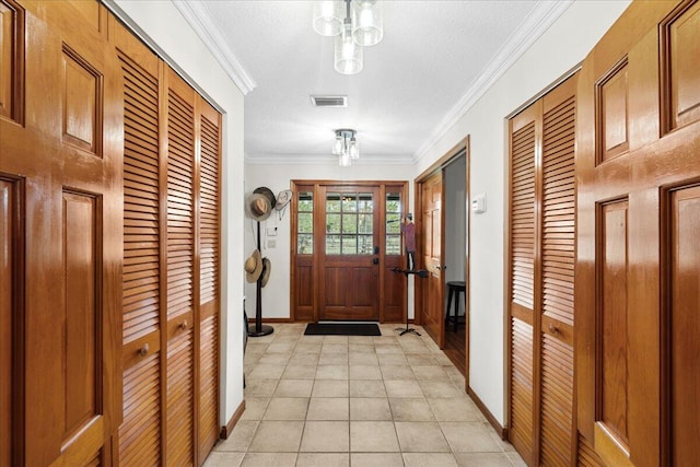 entryway featuring light tile patterned floors, a textured ceiling, and crown molding