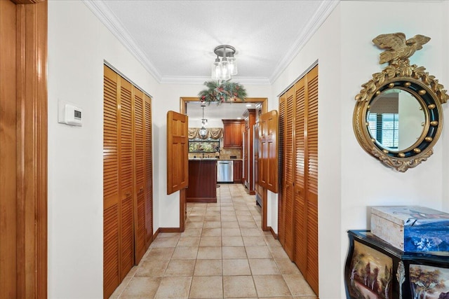 corridor with a textured ceiling, sink, light tile patterned floors, and crown molding