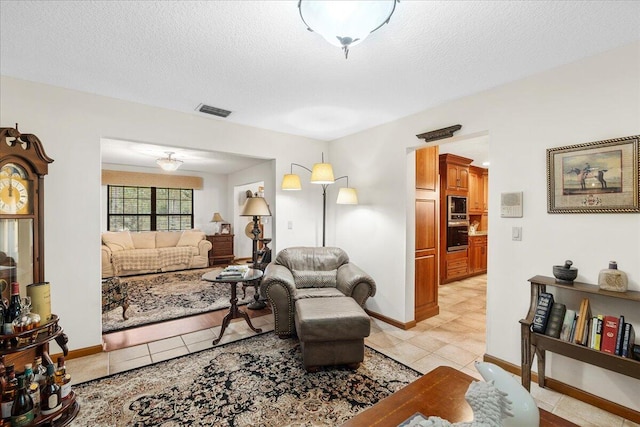 living room with light tile patterned flooring and a textured ceiling