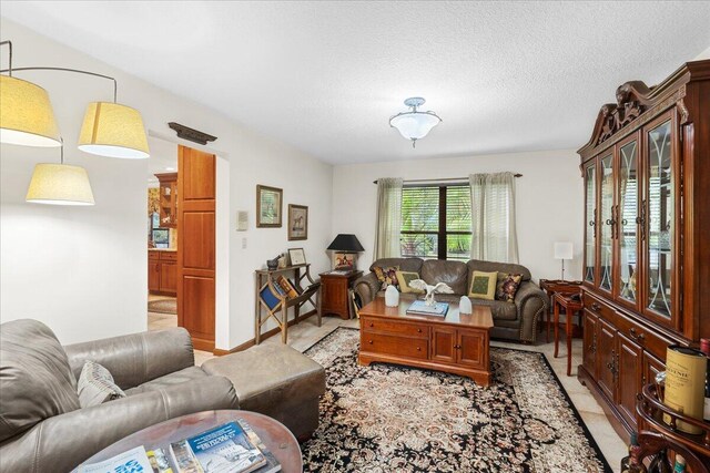 living room with light tile patterned flooring and a textured ceiling