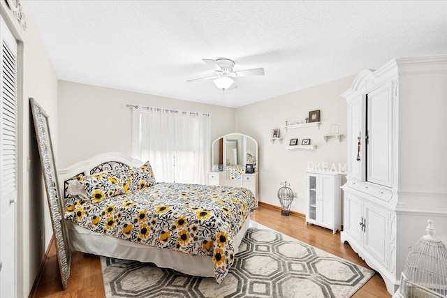 bedroom with ceiling fan, a closet, a textured ceiling, and hardwood / wood-style flooring