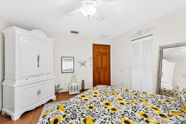 bedroom featuring a textured ceiling, light wood-type flooring, a closet, and ceiling fan