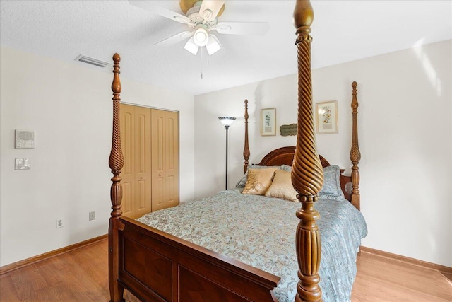 bedroom featuring a textured ceiling, ceiling fan, light hardwood / wood-style flooring, and a closet