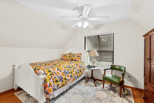 bedroom with light hardwood / wood-style floors, vaulted ceiling, and ceiling fan