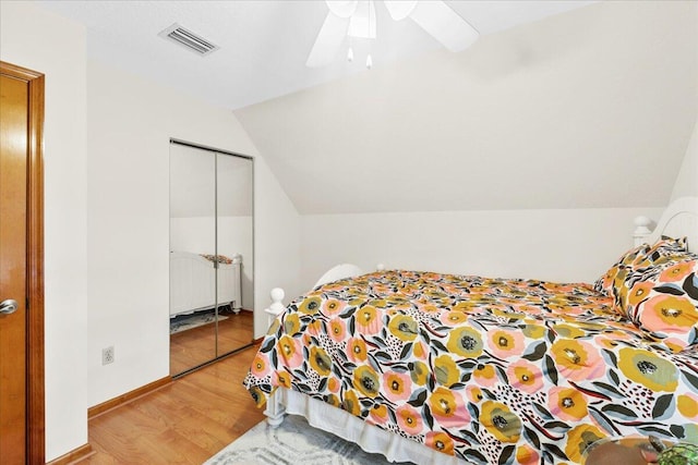 bedroom with hardwood / wood-style flooring, ceiling fan, vaulted ceiling, and a closet