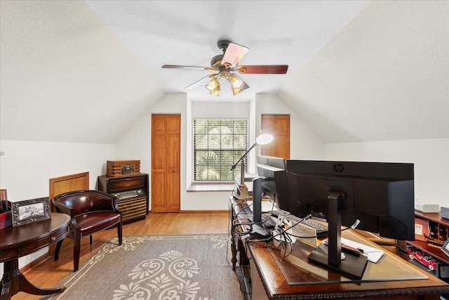 office area with a textured ceiling, ceiling fan, light hardwood / wood-style flooring, and vaulted ceiling