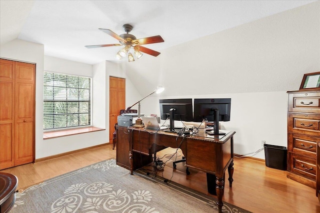 home office with ceiling fan, light wood-type flooring, and vaulted ceiling