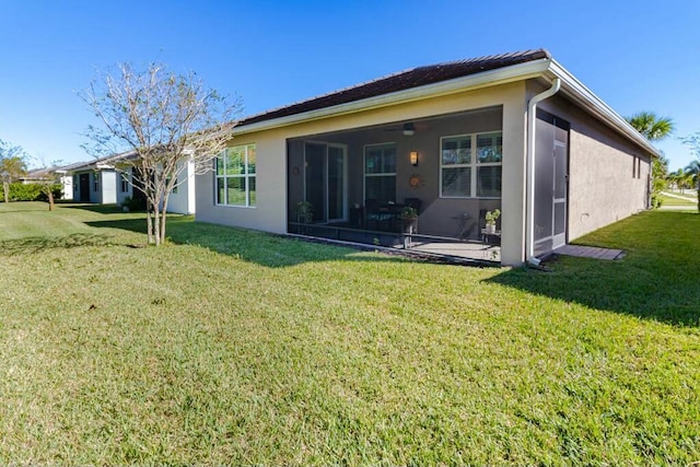 rear view of house with a sunroom and a yard