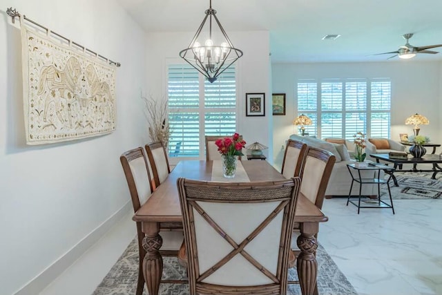 dining space featuring ceiling fan with notable chandelier