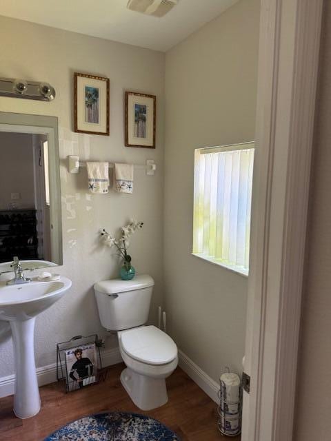 bathroom with hardwood / wood-style floors and toilet