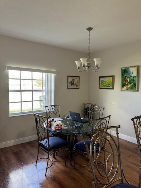 dining area with a chandelier and dark hardwood / wood-style flooring