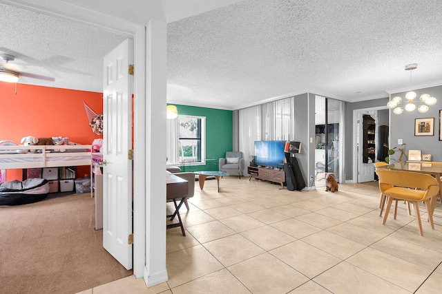 interior space with ceiling fan, a textured ceiling, and ornamental molding