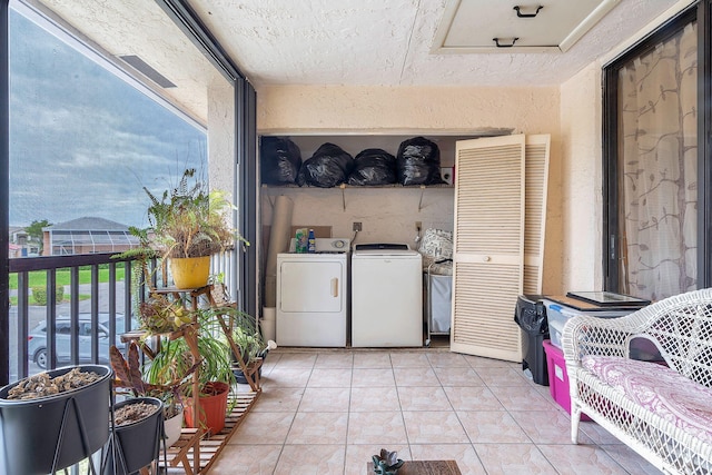 laundry area with washer and clothes dryer and light tile patterned floors