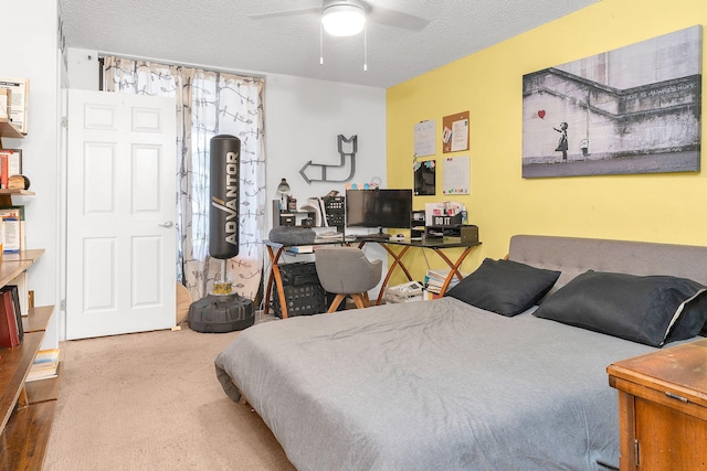 bedroom with ceiling fan, carpet floors, and a textured ceiling