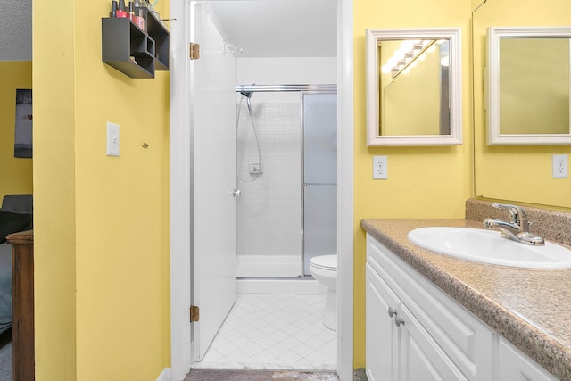 bathroom with tile patterned flooring, vanity, an enclosed shower, and toilet