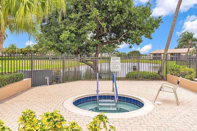 view of swimming pool with a water view and a hot tub