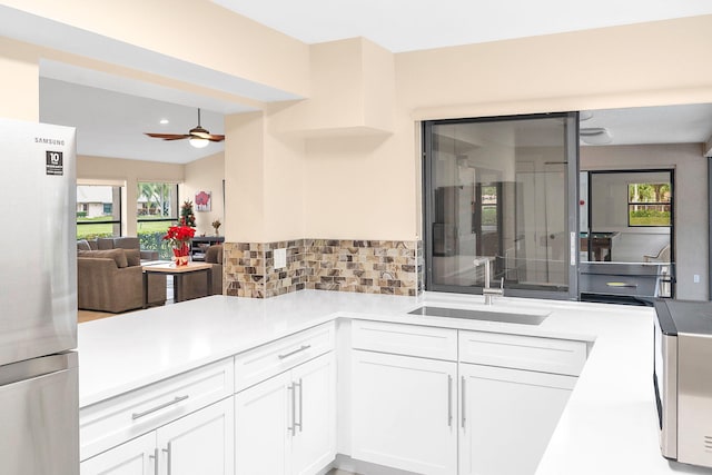 kitchen featuring white cabinetry, sink, ceiling fan, decorative backsplash, and appliances with stainless steel finishes