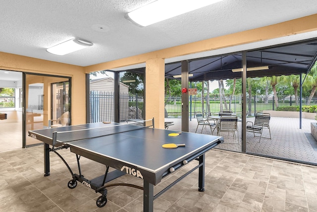 playroom with french doors, a textured ceiling, and vaulted ceiling