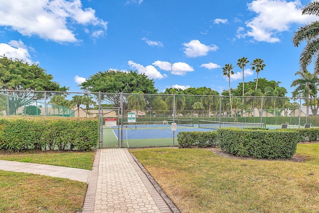 view of tennis court with a yard