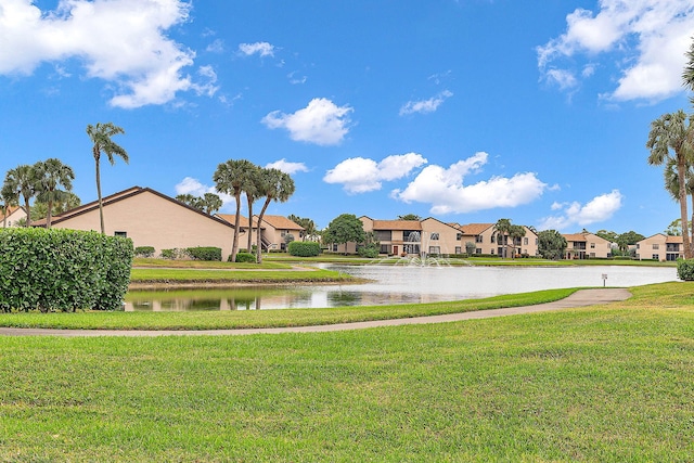 view of property's community with a yard and a water view