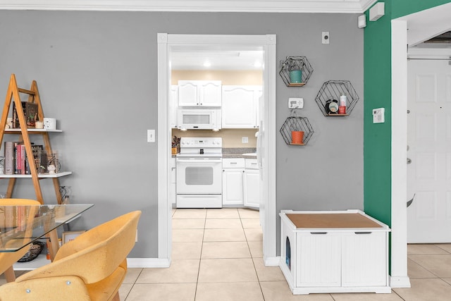 kitchen with white cabinetry, light tile patterned floors, white appliances, and ornamental molding