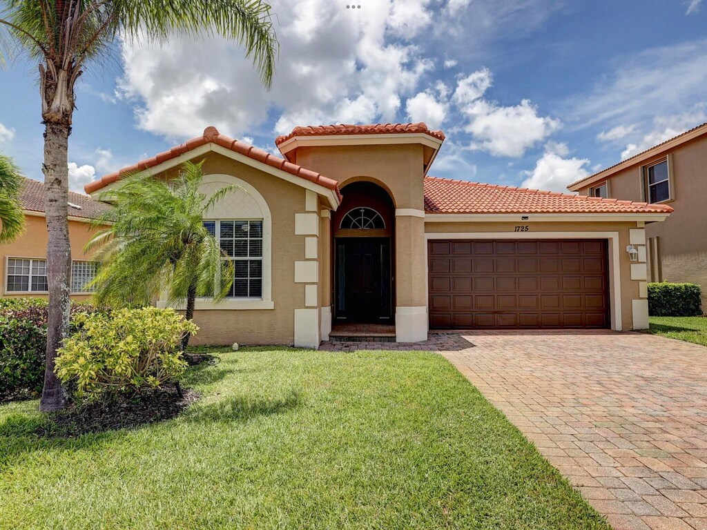 mediterranean / spanish house with a front yard and a garage