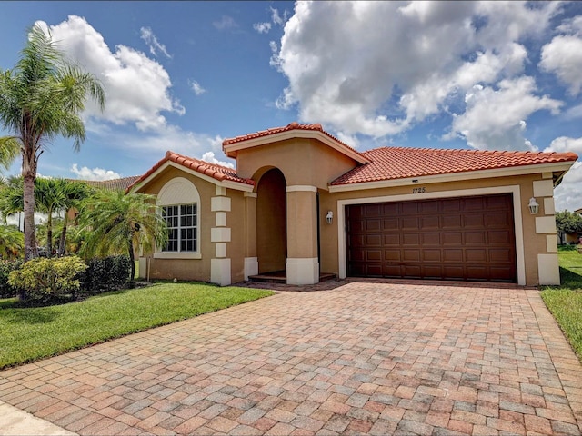 mediterranean / spanish-style house with a front yard and a garage