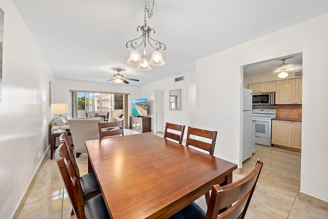 tiled dining area featuring ceiling fan with notable chandelier