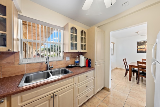 kitchen with backsplash, cream cabinets, sink, ceiling fan, and light tile patterned floors