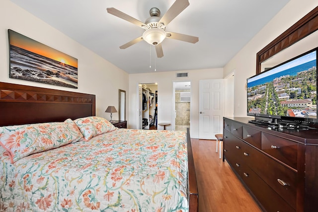 bedroom featuring connected bathroom, ceiling fan, a spacious closet, light hardwood / wood-style flooring, and a closet