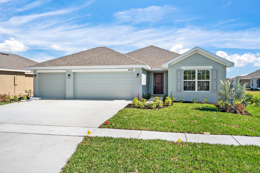 single story home with a garage and a front lawn