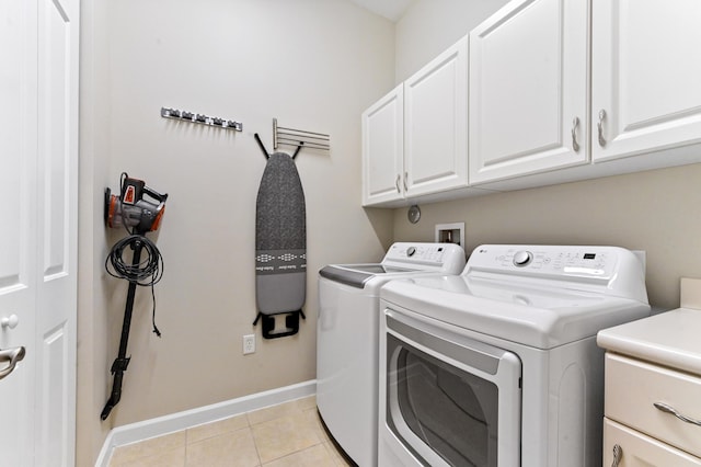 washroom featuring washer and dryer, light tile patterned flooring, and cabinets