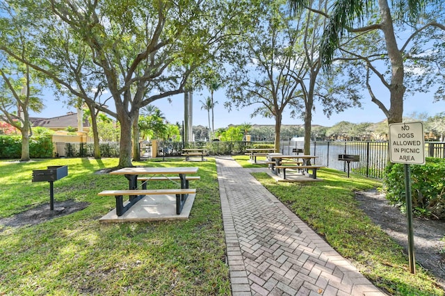 surrounding community with a lawn and a water view