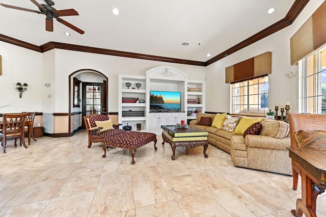 living room with built in shelves, ceiling fan, and ornamental molding