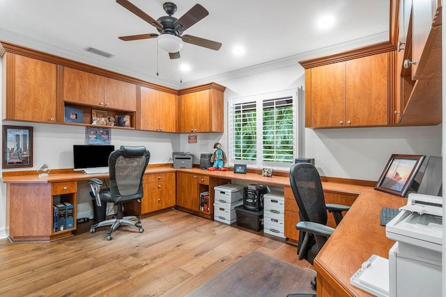 office area with ceiling fan, built in desk, light hardwood / wood-style floors, and ornamental molding