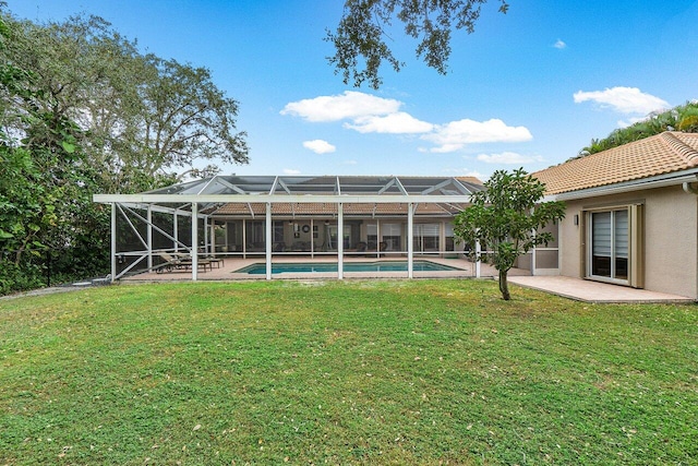 back of property featuring a lawn and glass enclosure