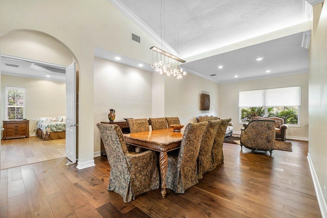 dining area with crown molding, a healthy amount of sunlight, and hardwood / wood-style flooring