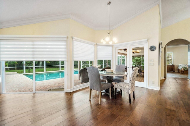 dining area with dark hardwood / wood-style flooring, a chandelier, lofted ceiling, and ornamental molding