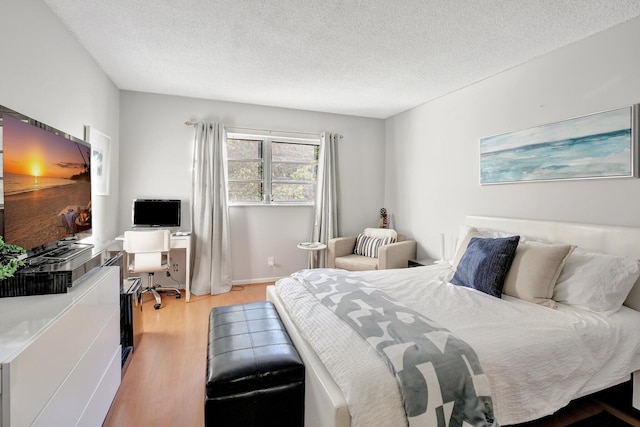 bedroom featuring light hardwood / wood-style floors and a textured ceiling