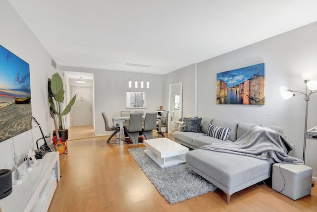 living room with an inviting chandelier and light hardwood / wood-style flooring