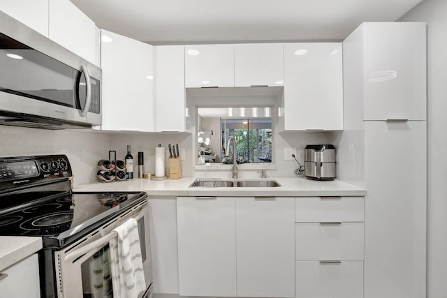1000 NE 12th Ave Unit 304, Hallandale Beach, FL 33009 - kitchen featuring electric range oven, stainless steel microwave, a sink, white cabinetry, and modern cabinets