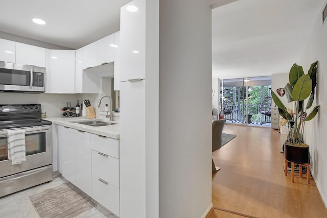1000 NE 12th Ave Unit 304, Hallandale Beach, FL 33009 - kitchen featuring appliances with stainless steel finishes, a sink, modern cabinets, light countertops, and white cabinetry