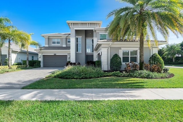 view of front of house with a garage and a front lawn