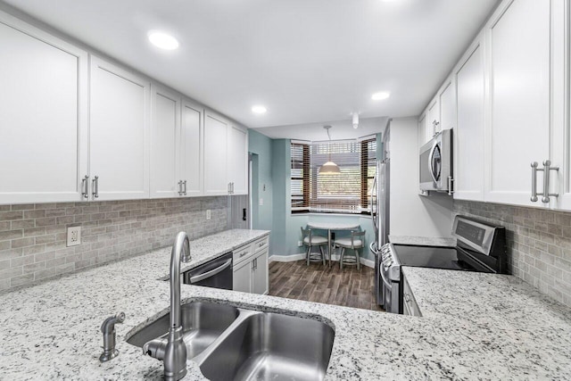 kitchen featuring backsplash, dark wood-type flooring, white cabinets, light stone counters, and stainless steel appliances