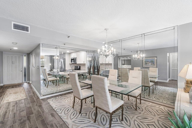 dining room with hardwood / wood-style floors, sink, and a textured ceiling